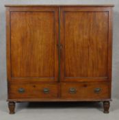 An early 19th century mahogany linen press with panel doors enclosing linen slides above a pair of