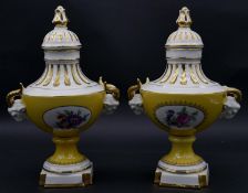 A pair of hand hand painted and gilded Dresden porcelain lidded urns with yellow ground and oval