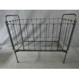 A Victorian wrought iron child's cot with fall front panel. H.114 L.124 W.63cm