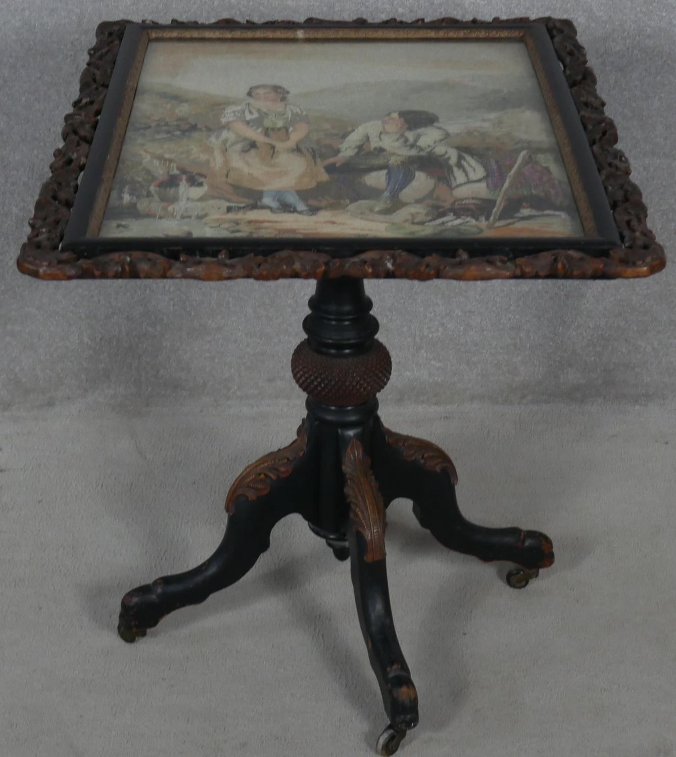 A Victorian carved and painted tilt top table with acorn and oak leaf detail and glazed inset