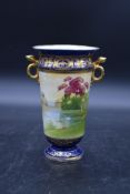 A Noritake twin handled vase in blue glaze with hand gilded and painted decoration with maker's mark