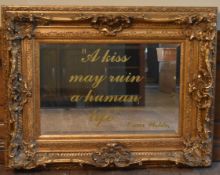 A gilt framed wall mirror in a heavy Rococo style frame, the bevelled plate with Oscar Wilde
