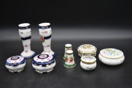 A pair of Continental porcelain candlesticks (chips to rim) with two matching lidded pots, three