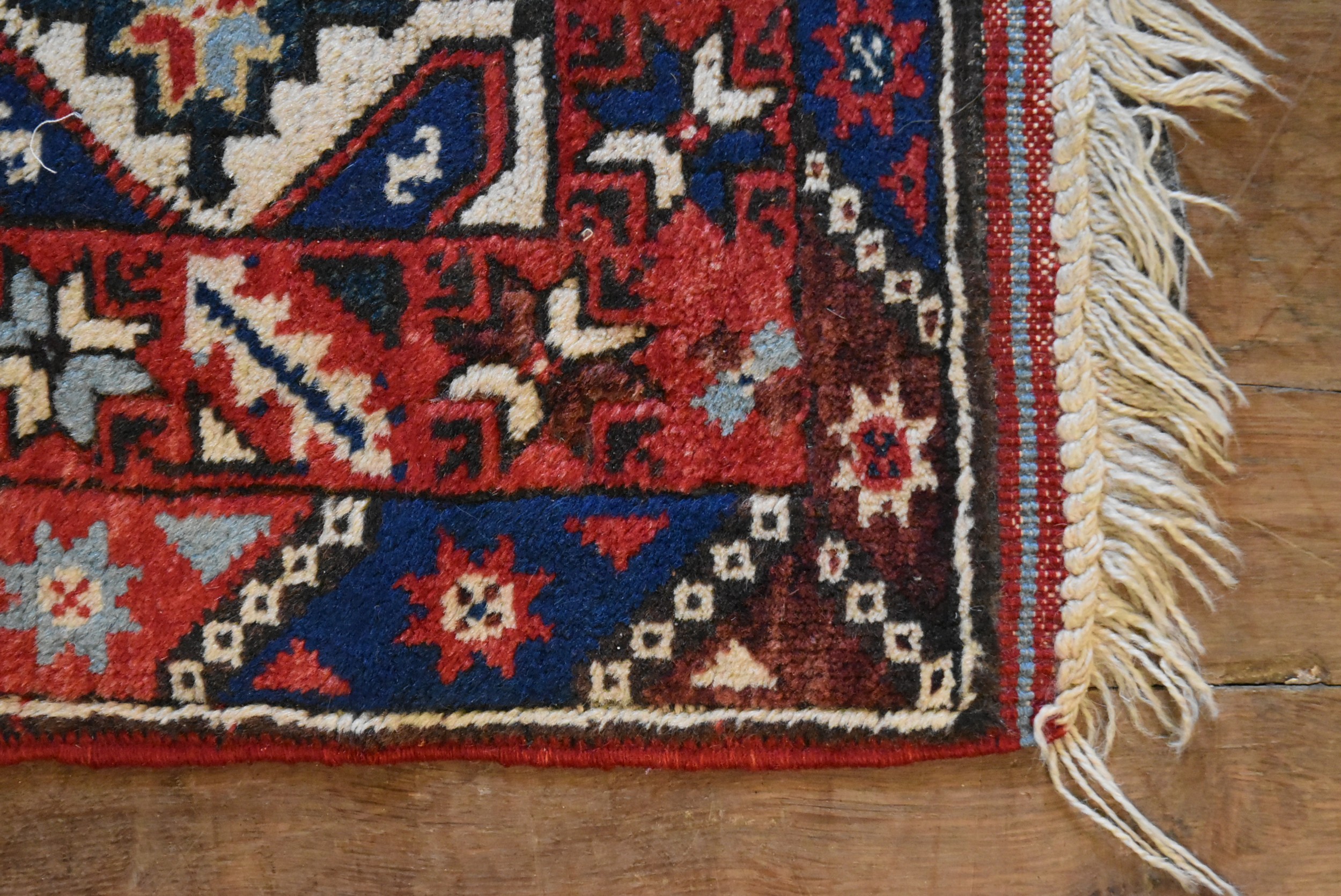 A Kazak rug with repeating stylised flowerhead motifs across the field contained by serrated palm - Image 3 of 4