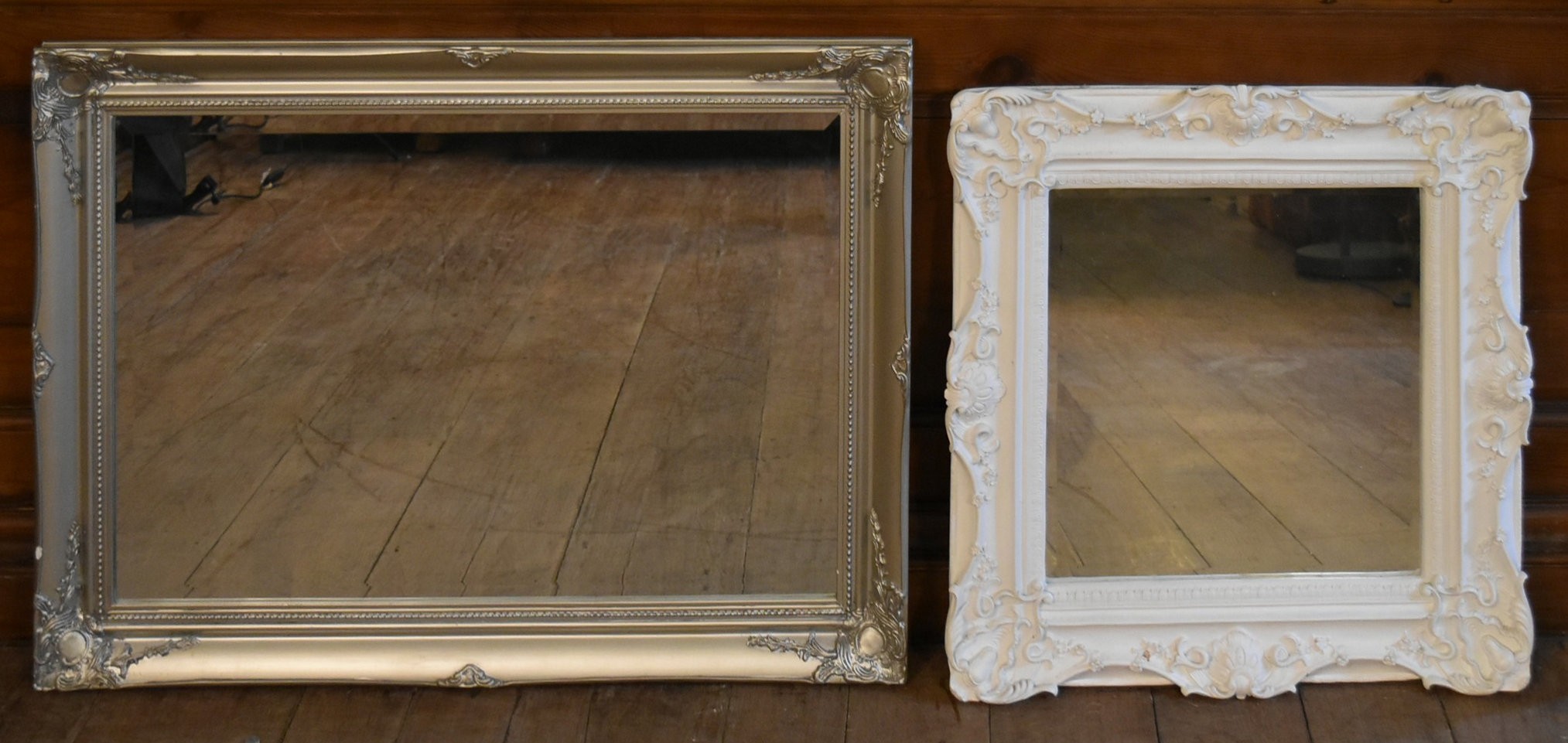 A white painted Rococo style wall mirror and a similar gilt example. H.90 W.64cm (largest)