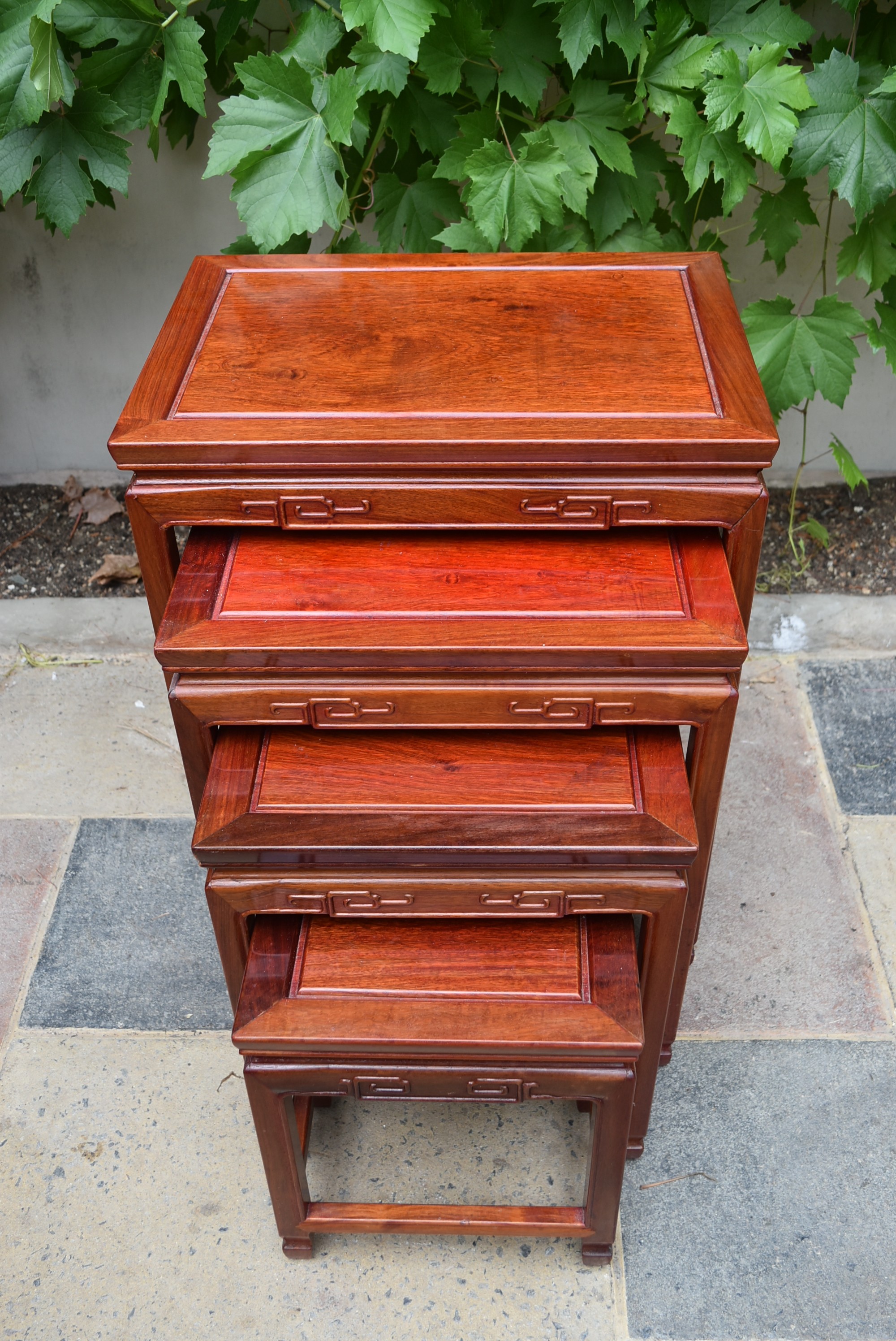 A nest of four Chinese hardwood graduating occasional tables with carved friezes on square - Image 3 of 4