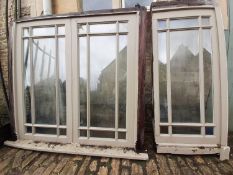 A painted hardwood window frame of eighteen double glazed panels and a similar single nine panel