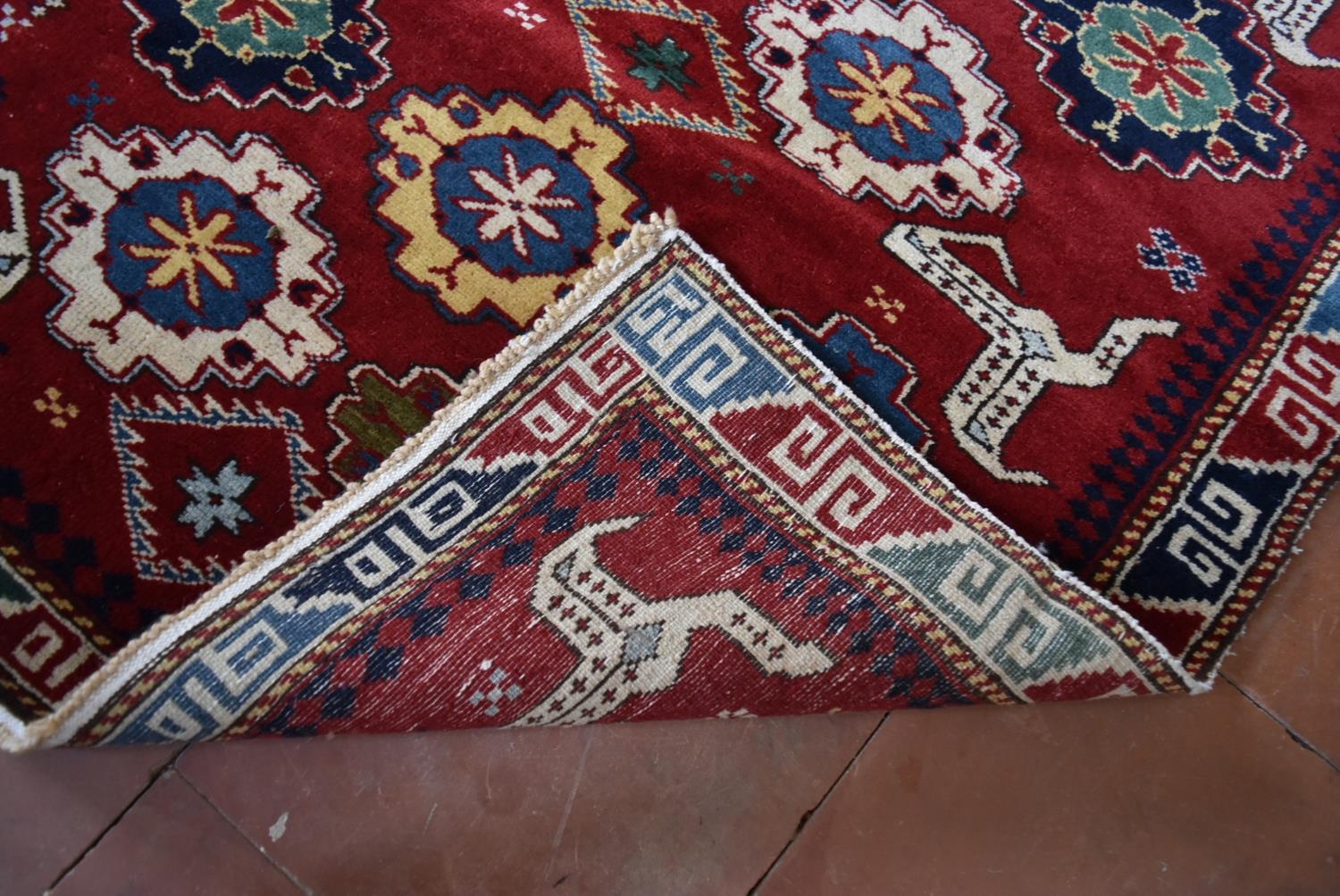 A Kazak design runner with stylised flowerhead and animal motifs across the madder ground within - Image 4 of 4