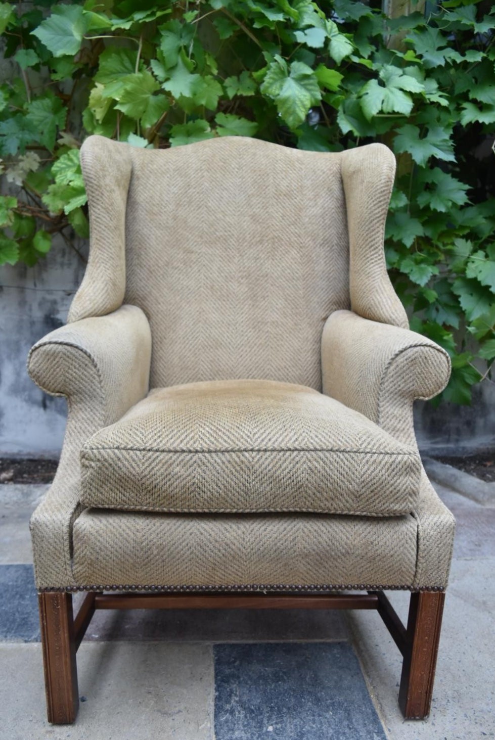 A Georgian style wingback armchair on square stretchered supports. H.109 W.82 D.84cm