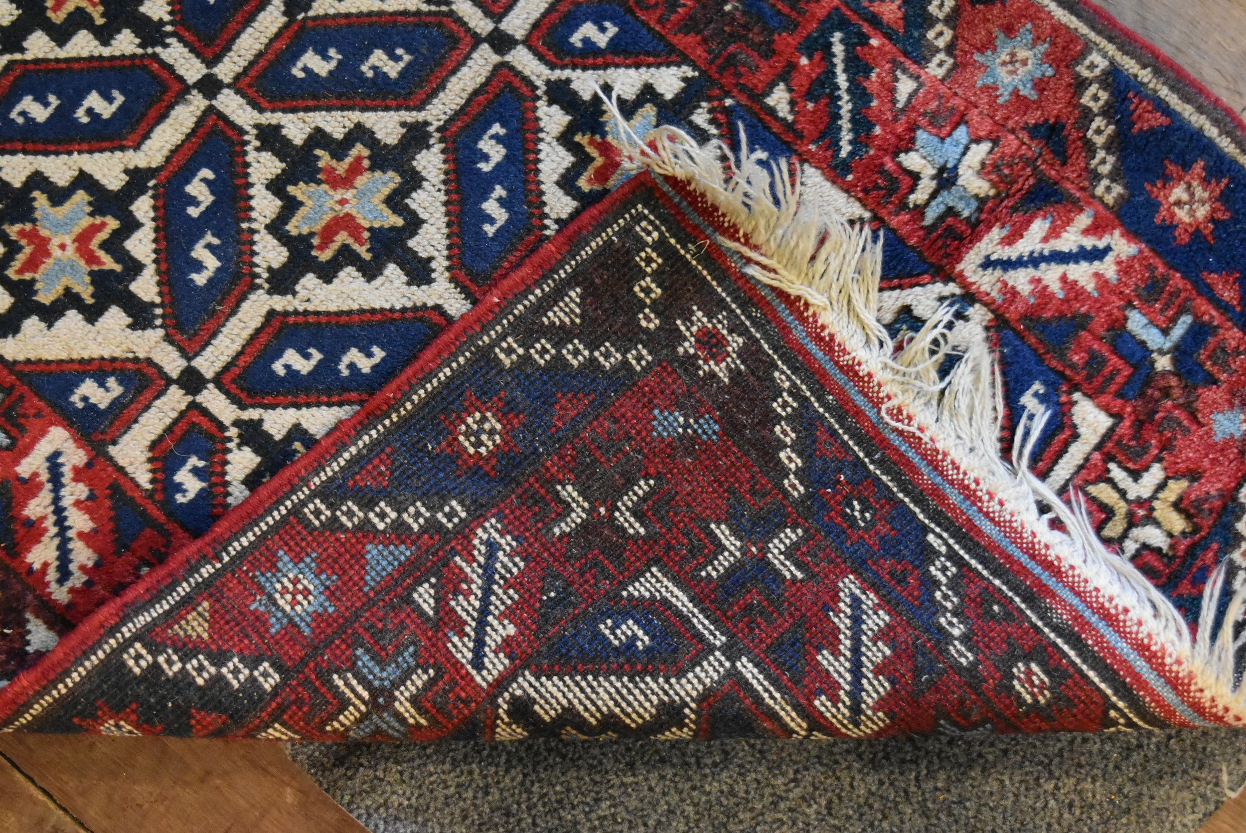 A Kazak rug with repeating stylised flowerhead motifs across the field contained by serrated palm - Image 4 of 4