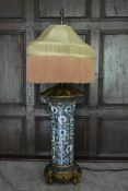 A contemporary lamp base in the style of a 19th century porcelain vase with fringed shade standing