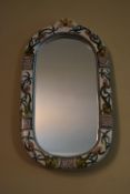 A wall mirror with hand decorated Majolica style ceramic frame. H.54 W.31cm