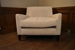 A contemporary armchair in cream calico upholstery on square tapering supports. H.80 W.90 D.70cm
