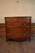 A Georgian mahogany and crossbanded bowfronted chest of two short drawers above three long drawers