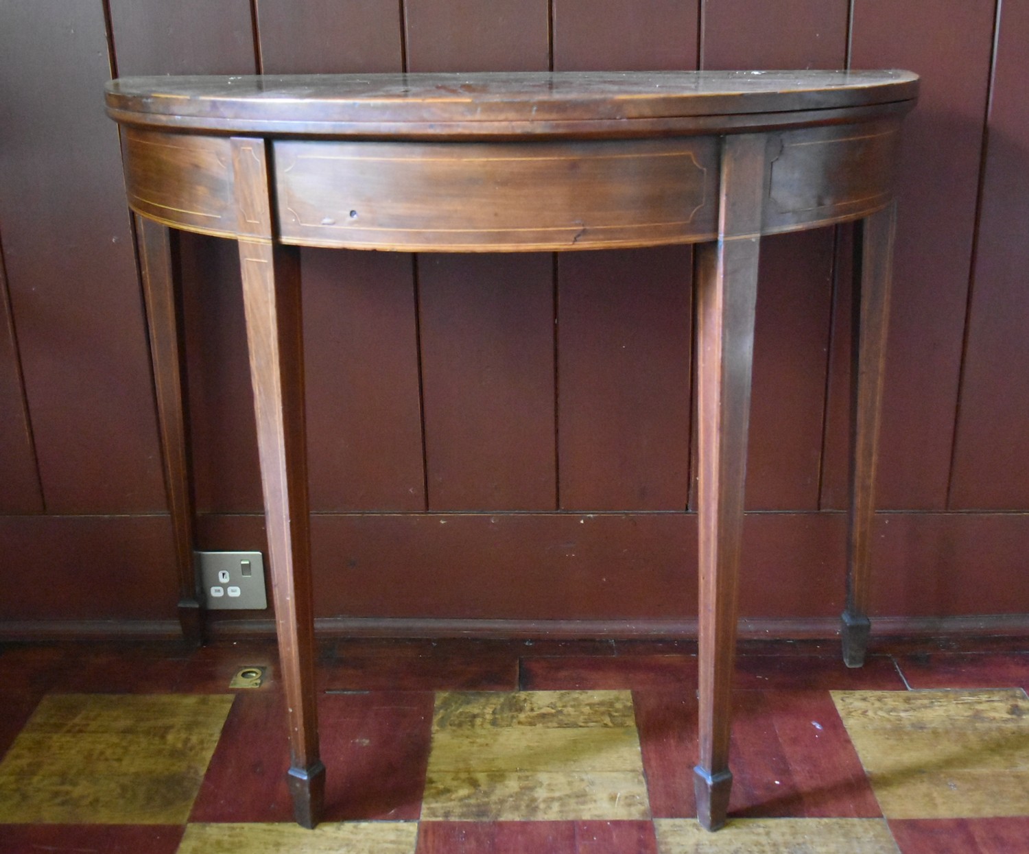 A Georgian mahogany and satinwood crossbanded demi lune tea table with fold over top on square