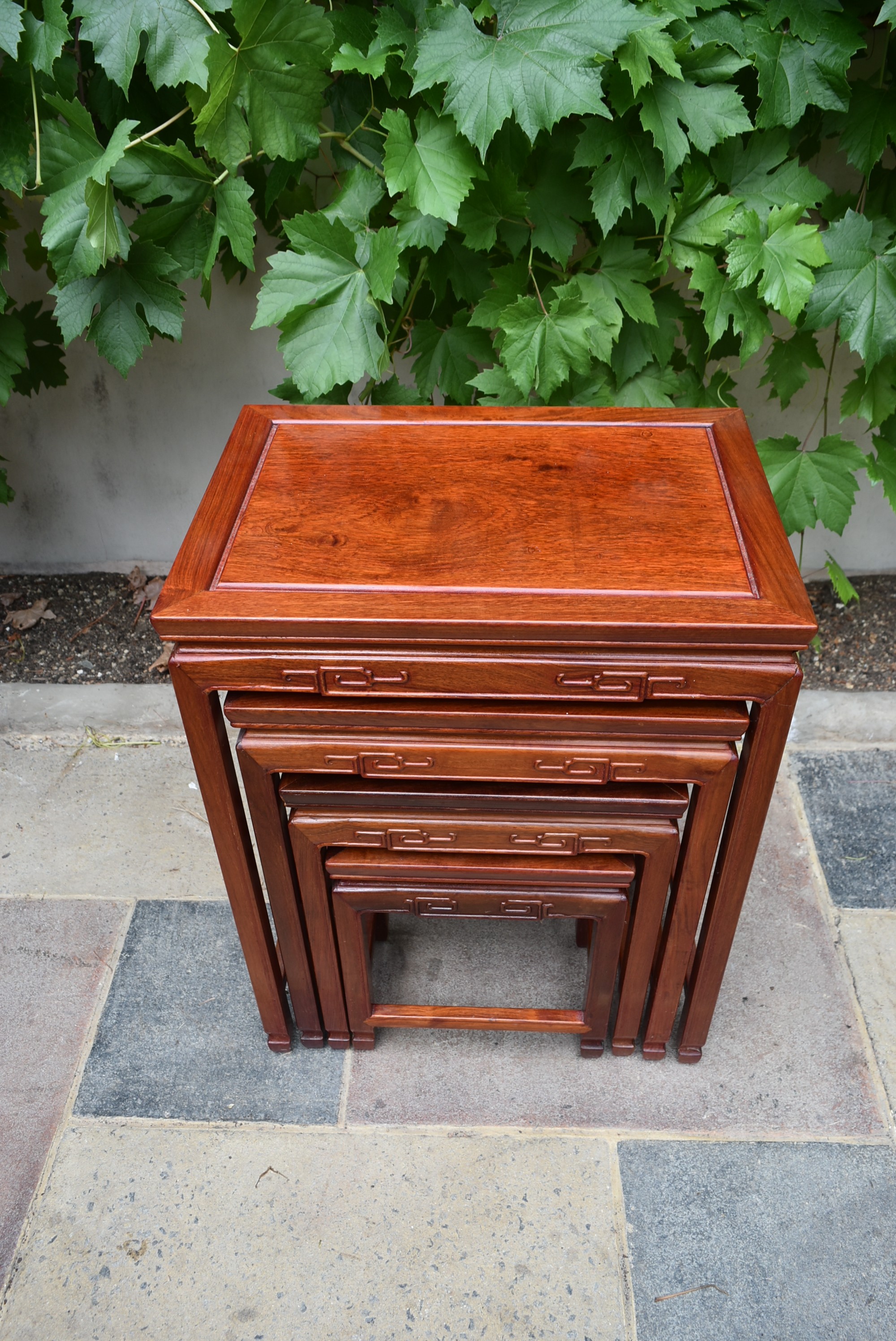 A nest of four Chinese hardwood graduating occasional tables with carved friezes on square - Image 4 of 4