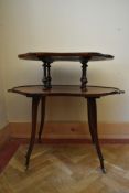 A 19th century rosewood two tier etagere with shaped top and brass carrying handles on slender