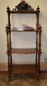 A Victorian rosewood four tier whatnot with pierced carved and mirrored back on turned supports. H.