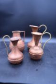 Four vintage copper and brass jugs. H.26 W.18cm