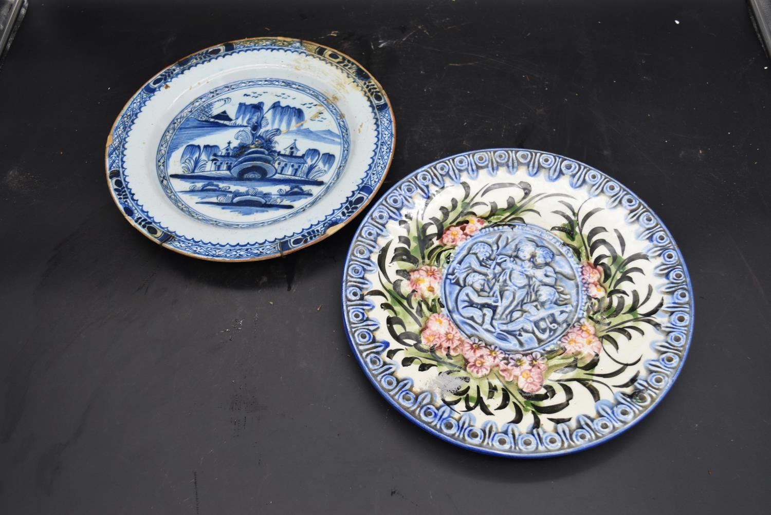 A Chinese blue and white plate and a Majolica plate decorated with cherubs. Dia.31cm (largest)