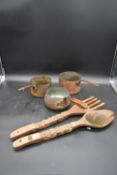 Three vintage hammered copper saucepans and a large carved Eastern fork and spoon. L.57cm