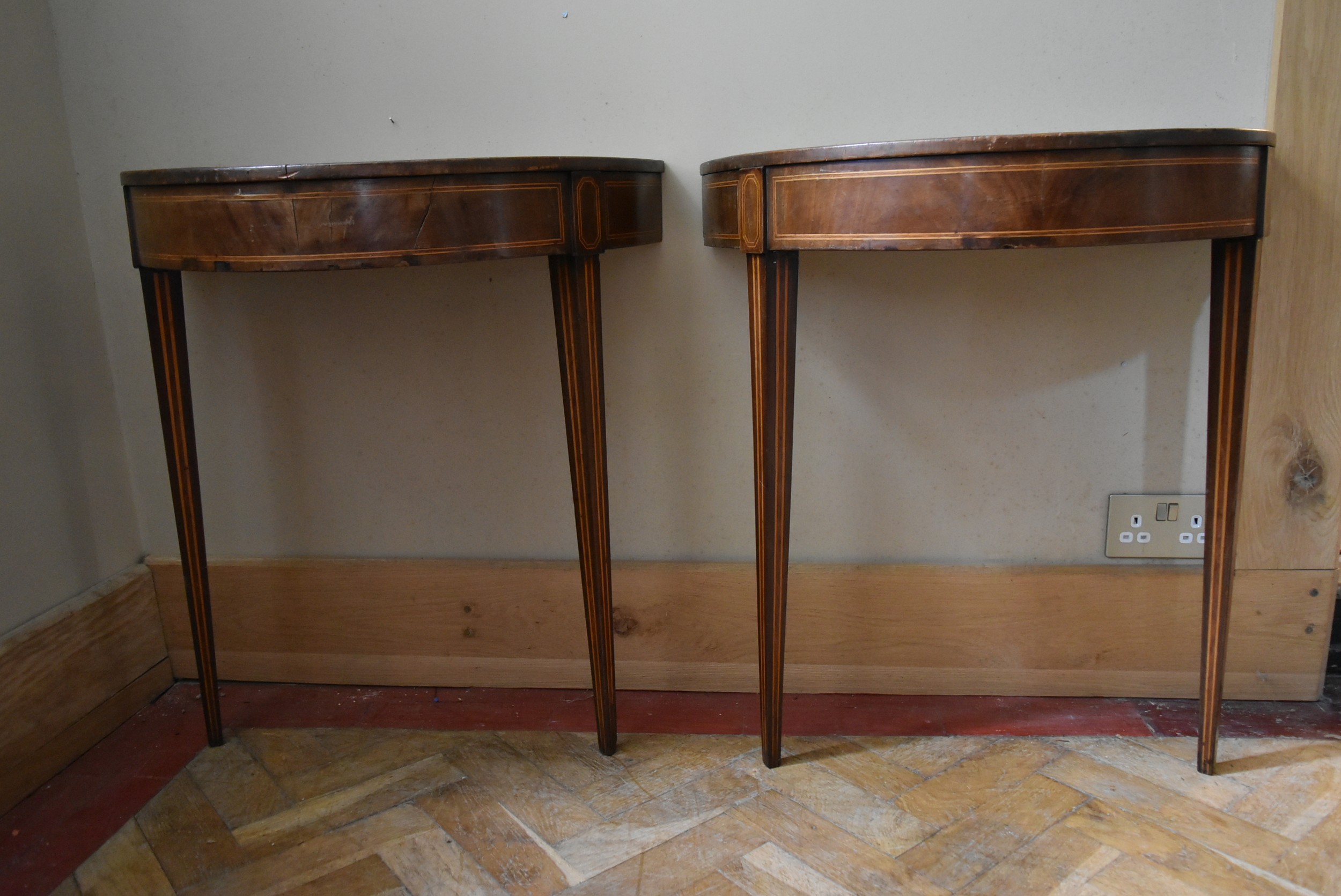 A pair of 19th century mahogany and satinwood strung demi lune console tables with inset leather