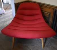 A contemporary retro style lounge salon chair in ribbed upholstery on an oak frame raised on tapered