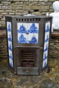 A late 19th century Dutch steel free standing fireplace with inset blue and white sailboat tiles