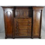 A mid 19th century mahogany compactum wardrobe with central drawers flanked by hanging sections on