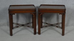 A pair of Georgian style mahogany lamp or bedside tables on chamfered square section pierced