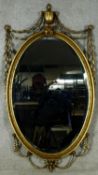An Adam style gilt and gesso wall mirror with Classical urn and ribbon decoration. H.130 W.70cm