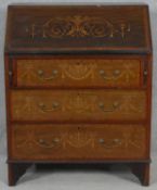 An Edwardian mahogany bureau with fitted interior and profuse all over ribbon and urn satinwood