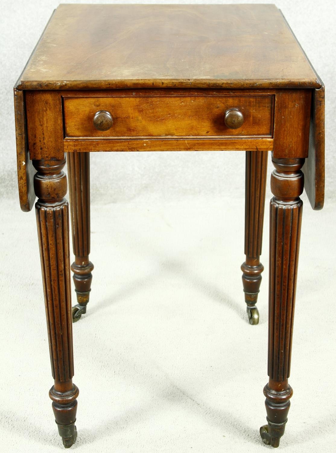 A small late Georgian mahogany drop flap Pembroke table with end drawer on tapering reeded