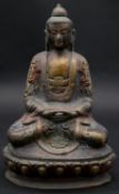 An oriental 20th century painted brass Buddha statue in lotus position sitting among lotus petals.