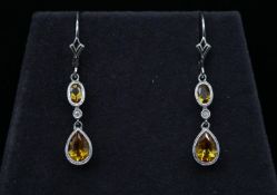 A pair of 14 carat and 9 carat white gold articulated citrine and diamond drop earrings. Each