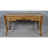 A French Provincial fruitwood Louis XV style bureau plat with three frieze drawers raised on slender