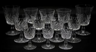 A collection of twelve glass sherry glasses with stylised foliate design and star cut bases. H.13cm