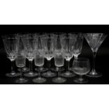 A collection of thirteen glasses to include eight wine glasses with faceted design along with