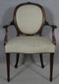 A late 19th century mahogany framed open armchair with husk carved back rail raised on fluted