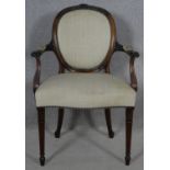 A late 19th century mahogany framed open armchair with husk carved back rail raised on fluted