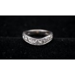 A platinum and diamond curved half eternity ring. Set with eleven round brilliant cut diamonds