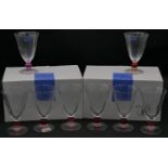 Three sets of Studio Nova drinking glasses, each with different coloured ball stem, one with red,