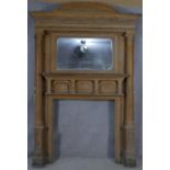 A large 19th century pitch pine fire surround and overmantel with architectural pediment above