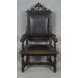 A late 19th century oak throne armchair in the Carolean style with carved cresting and arms in