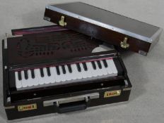 A modern portable harmonium from the Calcutta Harmonium Shop in metal bound hardwood carrying