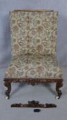 A mid Victorian carved mahogany nursing chair in floral upholstery on cabriole supports. H.110cm
