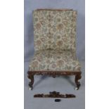 A mid Victorian carved mahogany nursing chair in floral upholstery on cabriole supports. H.110cm