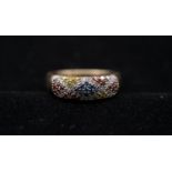 A 9 carat yellow gold and coloured diamond half eternity ring. Set to centre with nine round