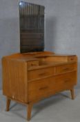 A mid century vintage teak dressing table with adjustable bevelled plate mirror above an arrangement