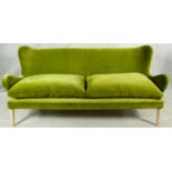 A retro style Designers Guild two seater sofa in velour upholstery on shaped tapering supports. H.92